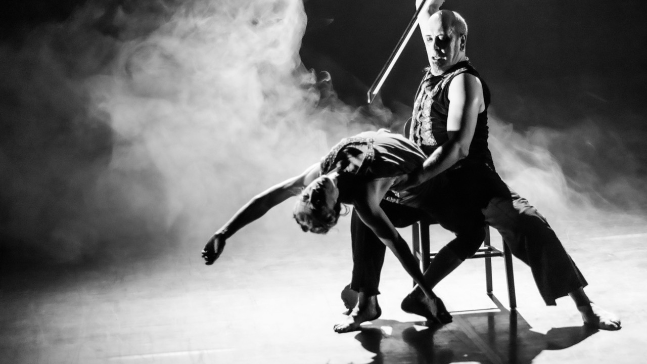 En man och en kvinna dansar dramatiskt i svartvitt.